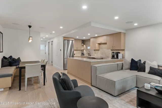 a living room with furniture and kitchen view