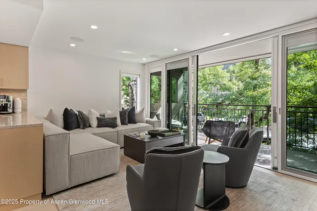 a living room with furniture and a floor to ceiling window