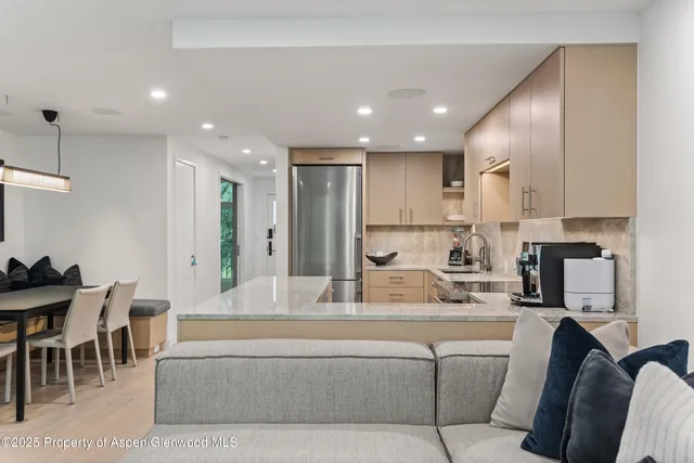 a living room with furniture and a dining table with kitchen view