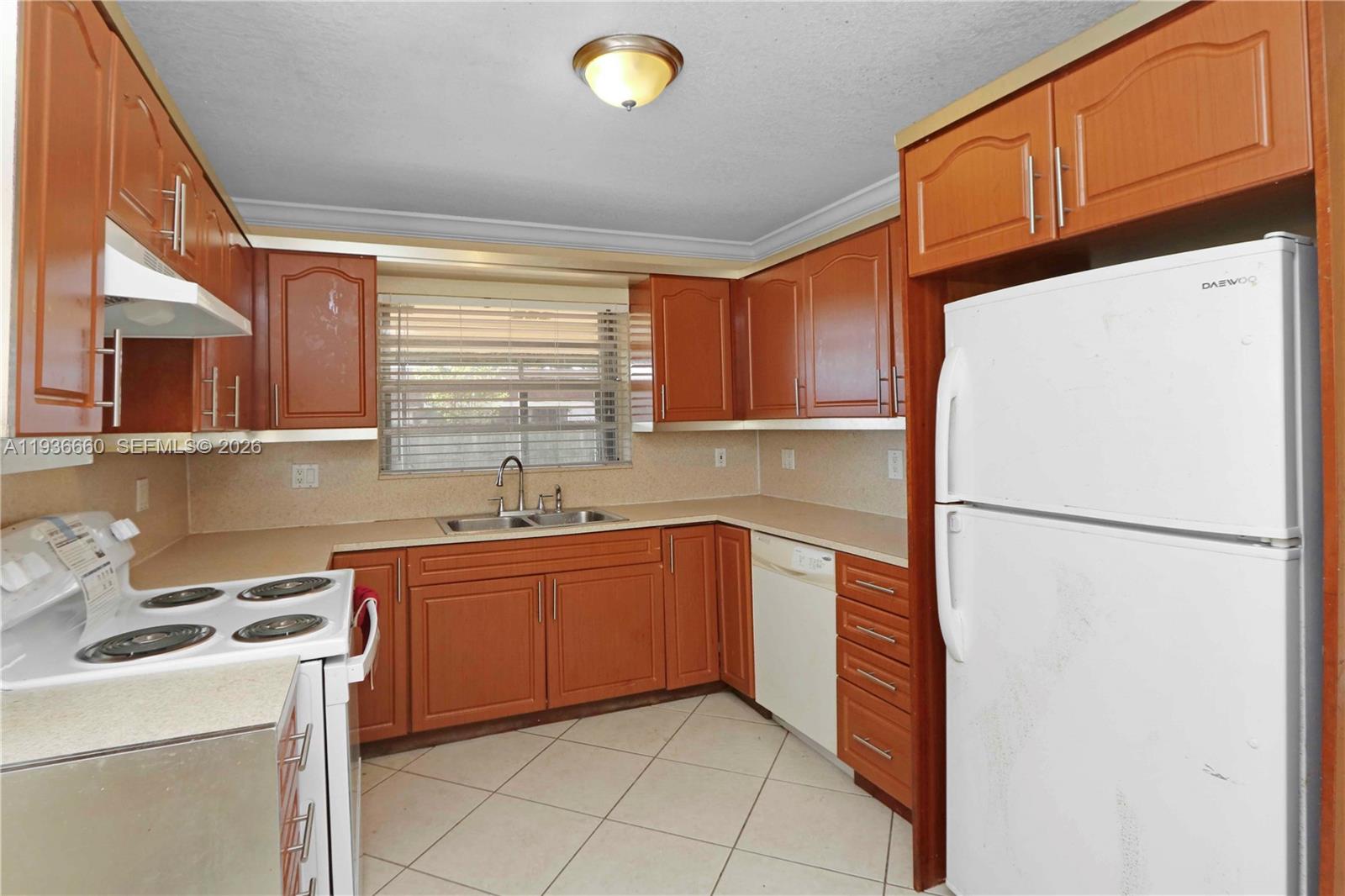 13254 Southwest 255th Terrace Homestead, FL 33032 - Photo 7 of 23 a kitchen with a sink a refrigerator and cabinets
