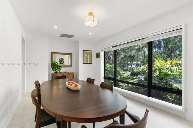 a view of a dining room with furniture wooden floor and a floor to ceiling window