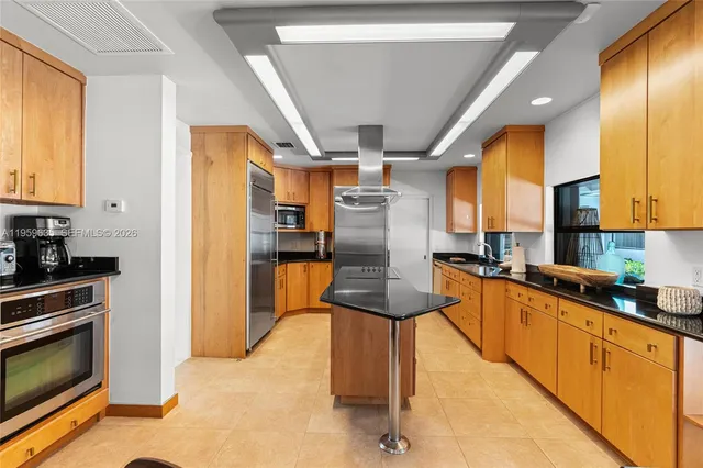 a kitchen with stainless steel appliances granite countertop a refrigerator a stove and a sink