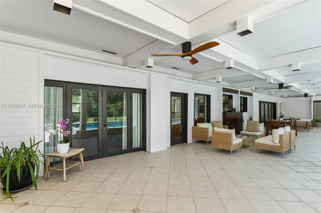 a living room with patio furniture and potted plants
