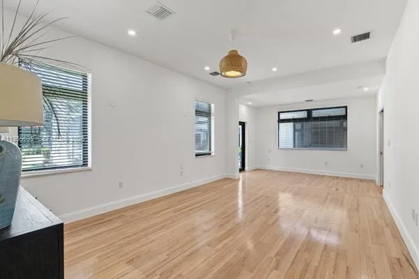 a view of a hallway with wooden floor and closet