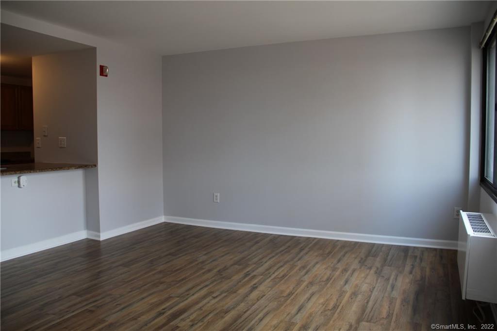 300 Broad Street, Unit 607 Stamford, CT 06901 - Photo 7 of 25 a view of an empty room with wooden floor and a flat screen tv