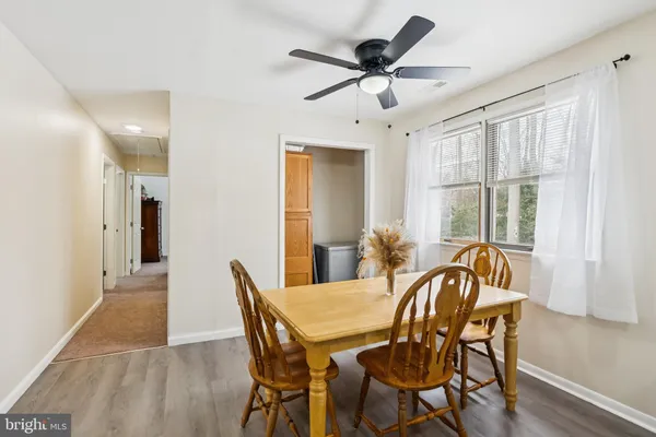 a kitchen with a dining table chairs and refrigerator