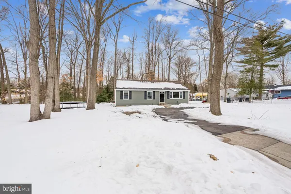 a front view of a house with a yard covered in snow