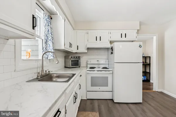 a kitchen with white cabinets and white appliances