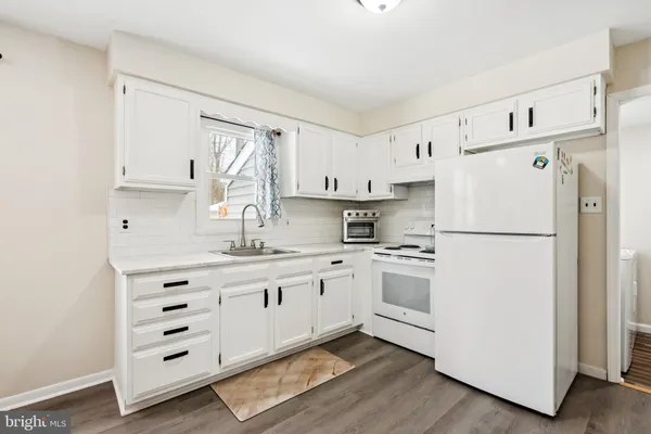 a kitchen with white cabinets and white appliances