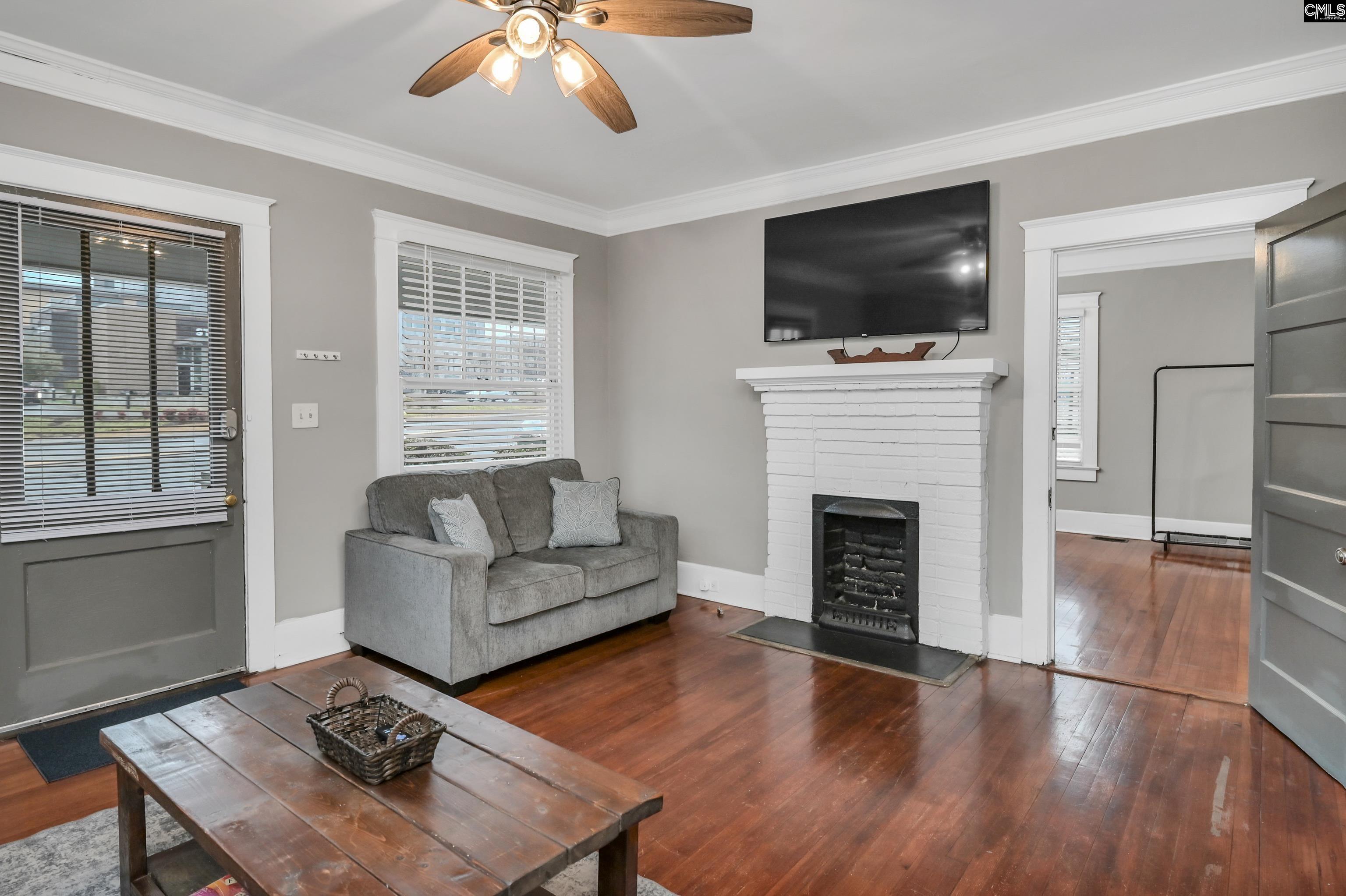 2227 Bull Street Columbia, SC 29201 - Photo 4 of 38 a living room with furniture a flat screen tv and a fireplace