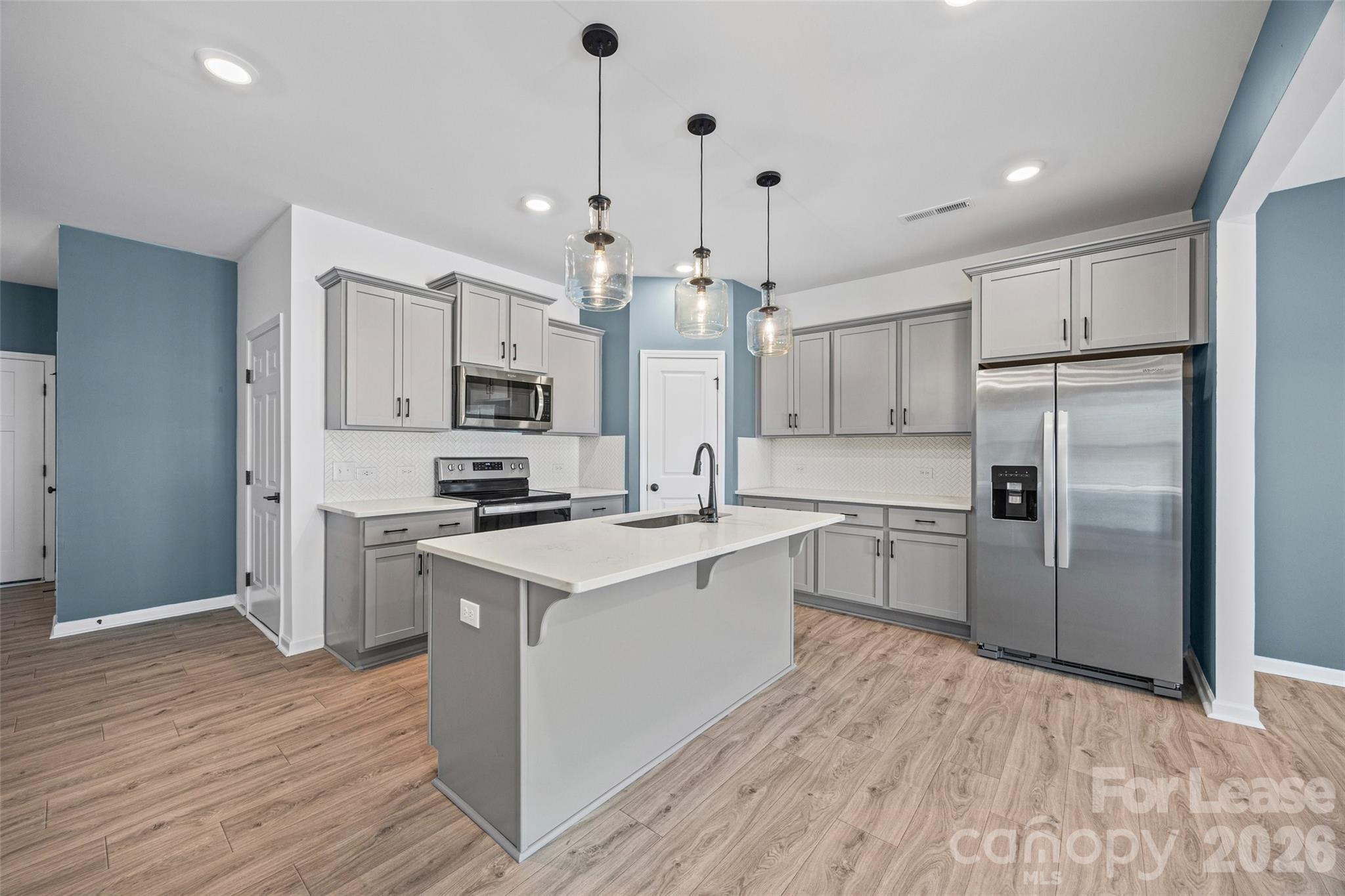 512 Station Street Clover, SC 29710 - Photo 5 of 34 a large kitchen with cabinets wooden floor and stainless steel appliances