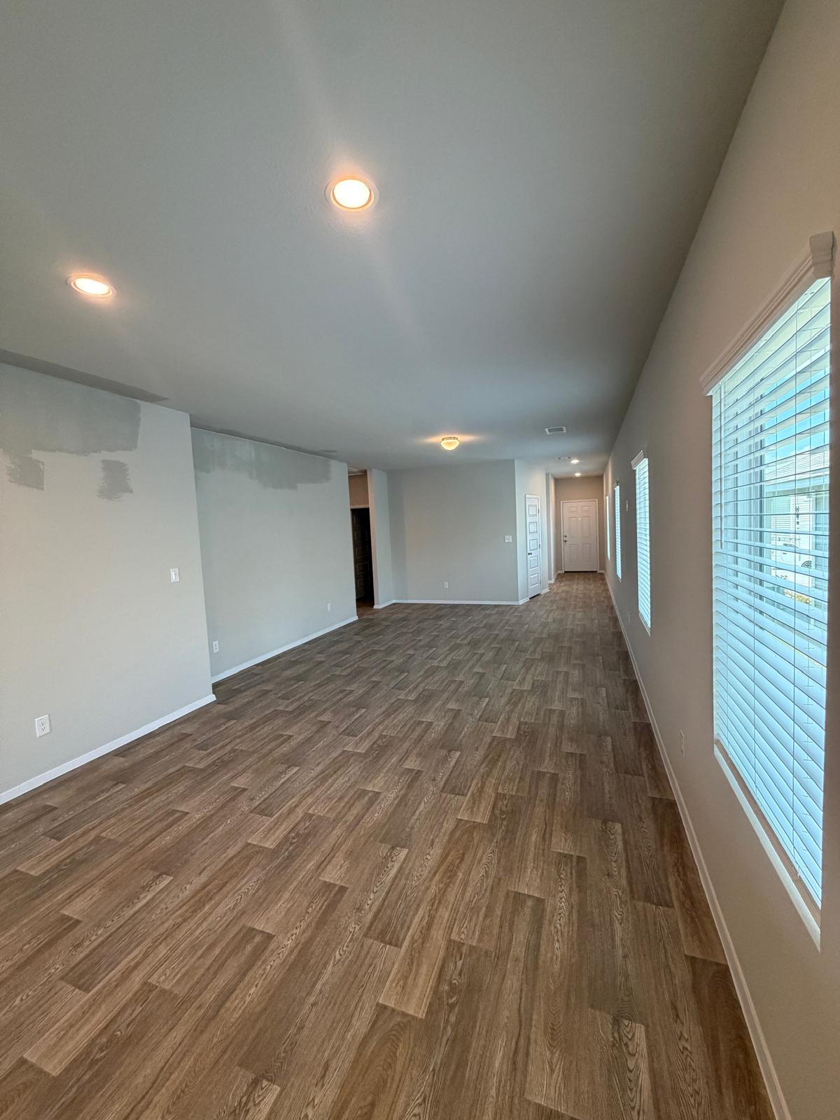 2701 Towy Road Manor, TX 78653 - Photo 8 of 35 Recessed lighting illuminates wood-look flooring in this spacious, open-concept living area.