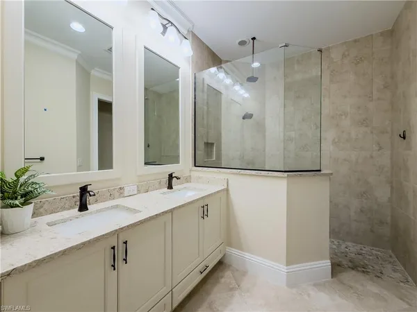 a bathroom with a double vanity sink mirror and shower