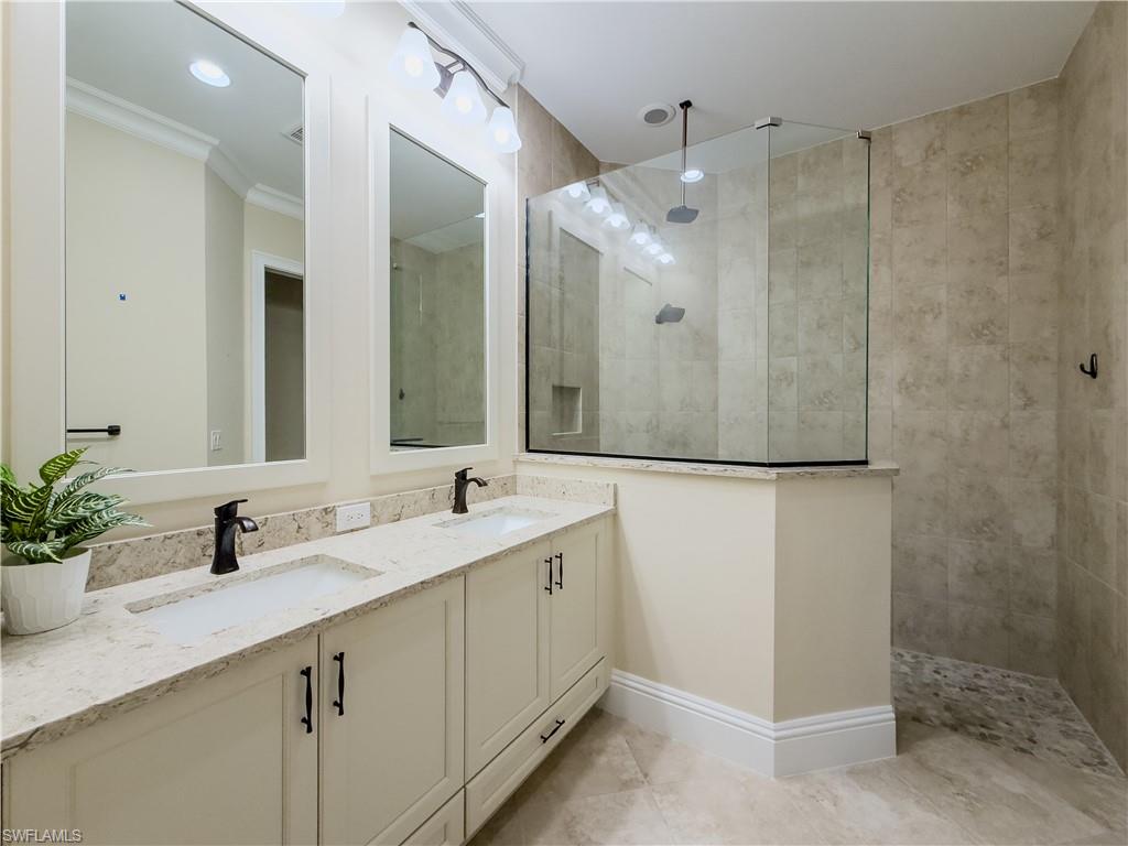 6399 Negril Isle Drive Naples, FL 34113 - Photo 14 of 33 a bathroom with a double vanity sink mirror and shower
