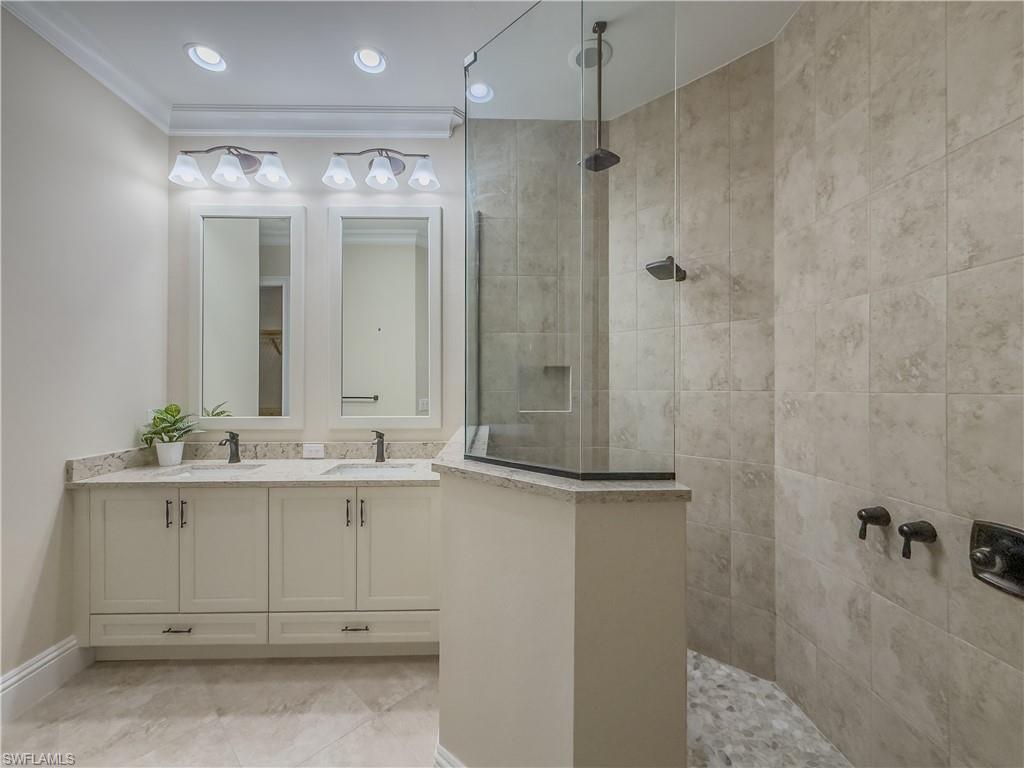 6399 Negril Isle Drive Naples, FL 34113 - Photo 15 of 33 a bathroom with a double vanity sink and mirror