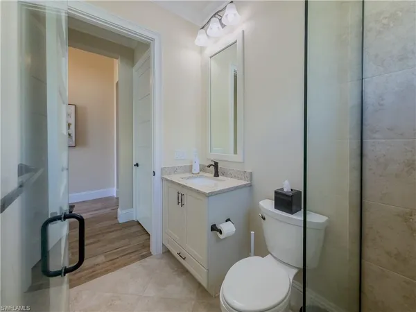 a bathroom with a toilet sink vanity and mirror