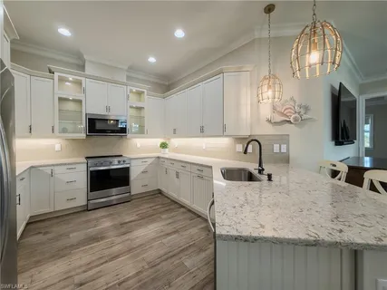 a large kitchen with kitchen island a sink stainless steel appliances and cabinets