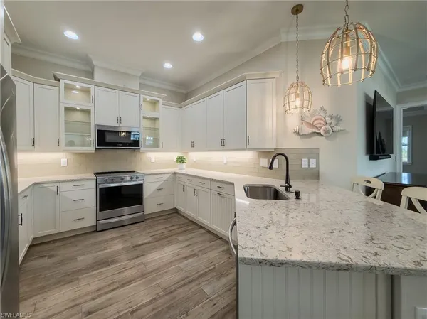 a large kitchen with kitchen island a sink stainless steel appliances and cabinets