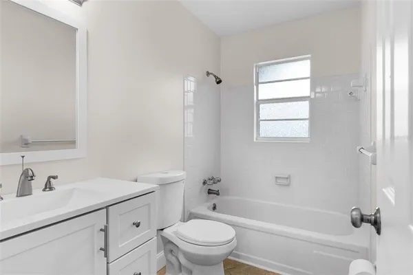 a bathroom with a sink toilet vanity and tub