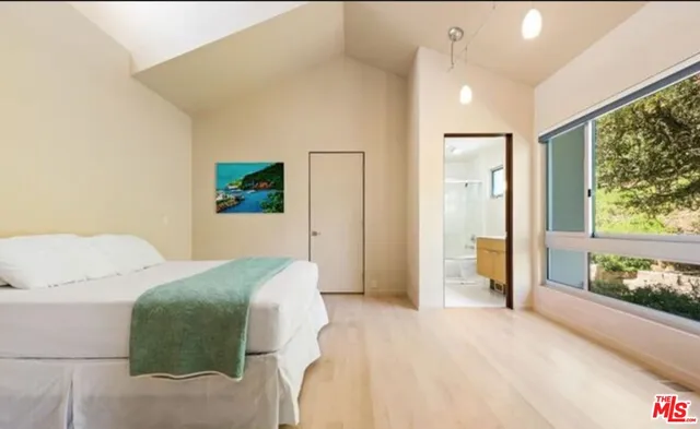 a spacious bedroom with a bed and a large window