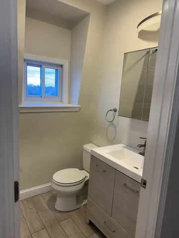 a bathroom with a toilet a sink and mirror