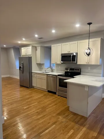 a kitchen with stainless steel appliances granite countertop a sink a stove top oven a refrigerator and a cabinets