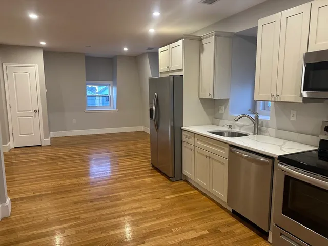 a kitchen with stainless steel appliances granite countertop a refrigerator stove top oven and sink