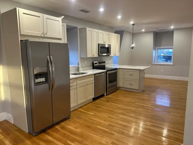 a kitchen with cabinets stainless steel appliances and a window