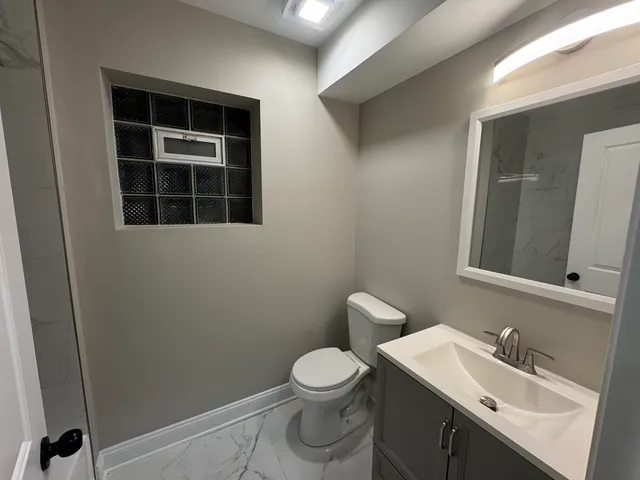 a bathroom with a toilet a sink a vanity and mirror