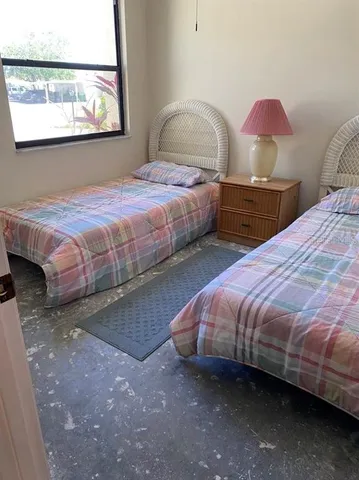 a bedroom with two beds and a painting on the wall
