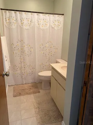 a bathroom with a toilet and a shower curtain