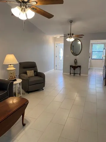 a living room with couches a dining table and a chandelier