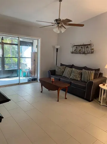 a living room with furniture and a floor to ceiling window