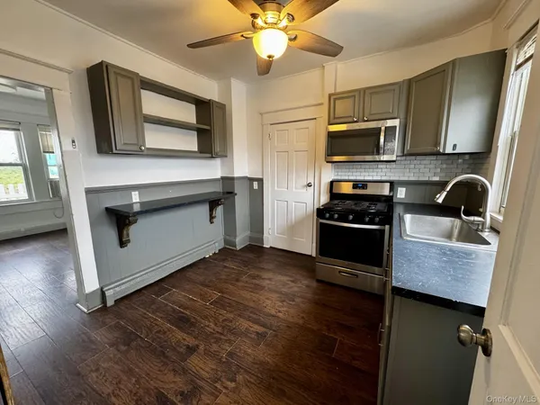 a kitchen with stainless steel appliances granite countertop a stove a microwave and a sink