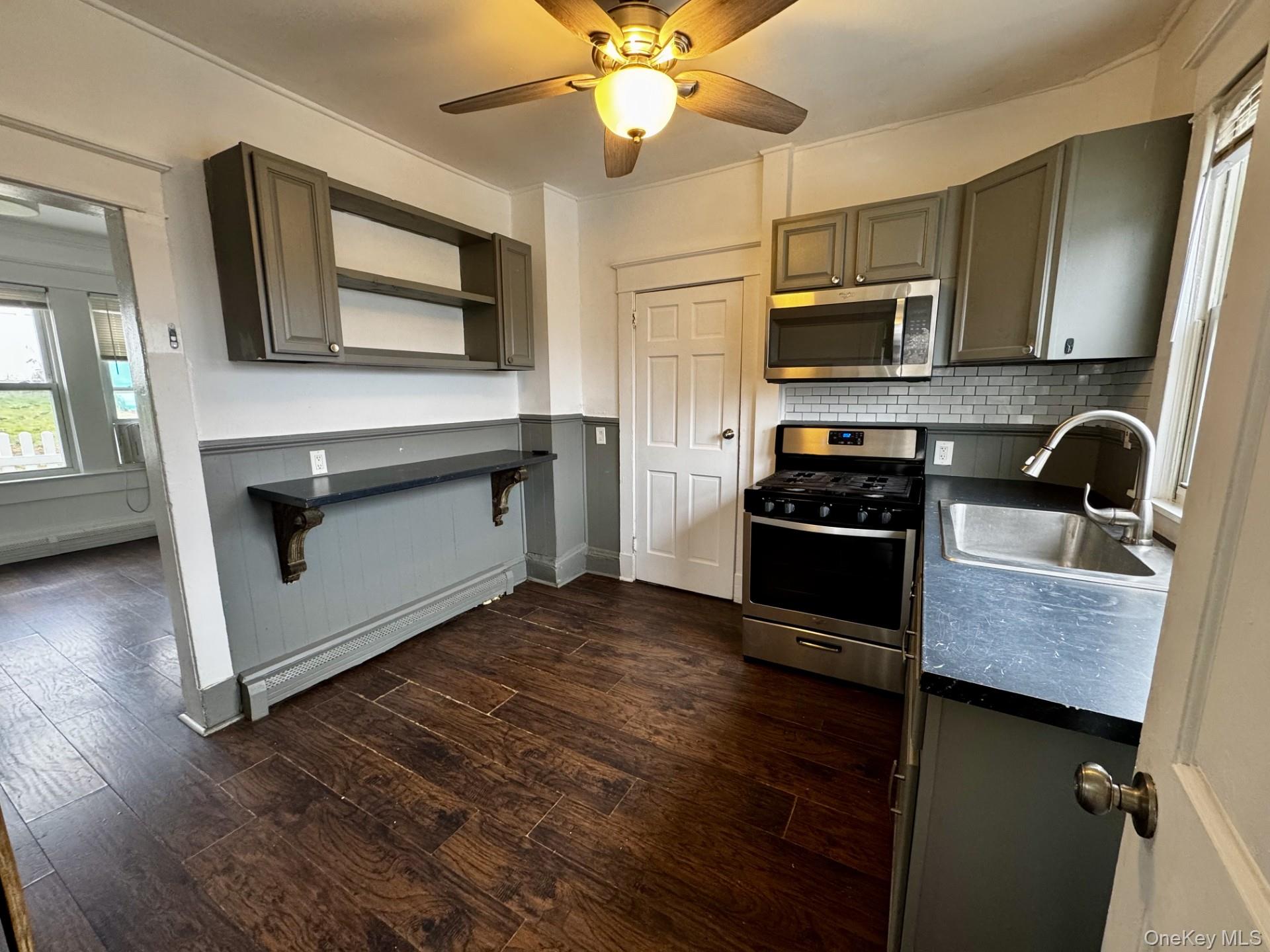 a kitchen with stainless steel appliances granite countertop a stove a microwave and a sink