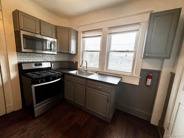 a kitchen with stainless steel appliances a stove a microwave and a sink