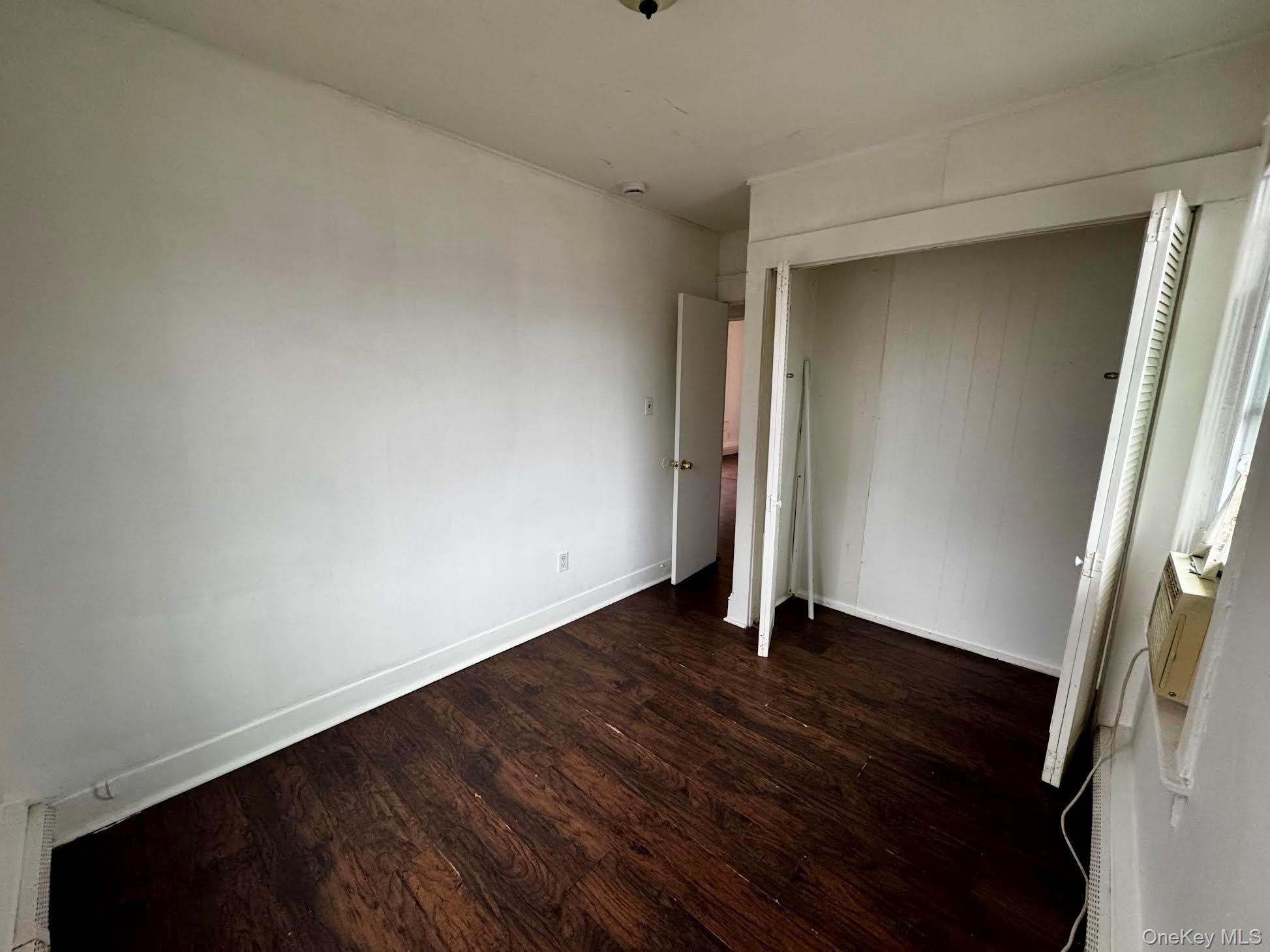298 Bleloch Avenue, Unit 1 Peekskill, NY 10566 - Photo 6 of 9 a view of an empty room with wooden floor and a window