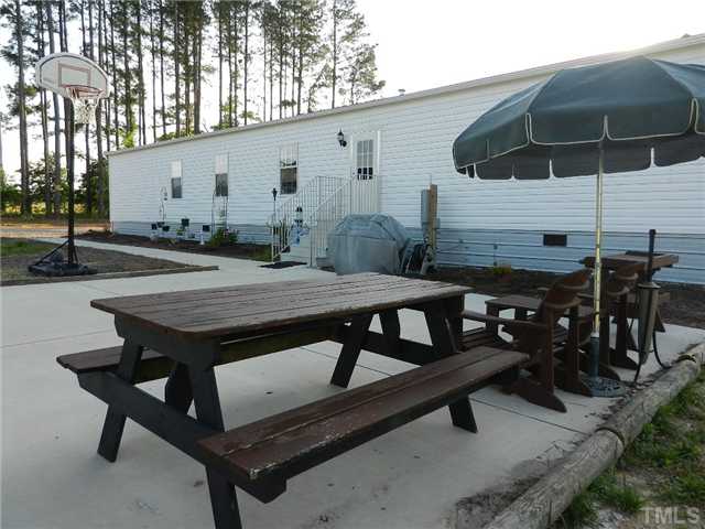 1184 Sykes Road Spring Hope, NC 27882 - Photo 7 of 12 a view of a patio with table and chairs with wooden floor and fence