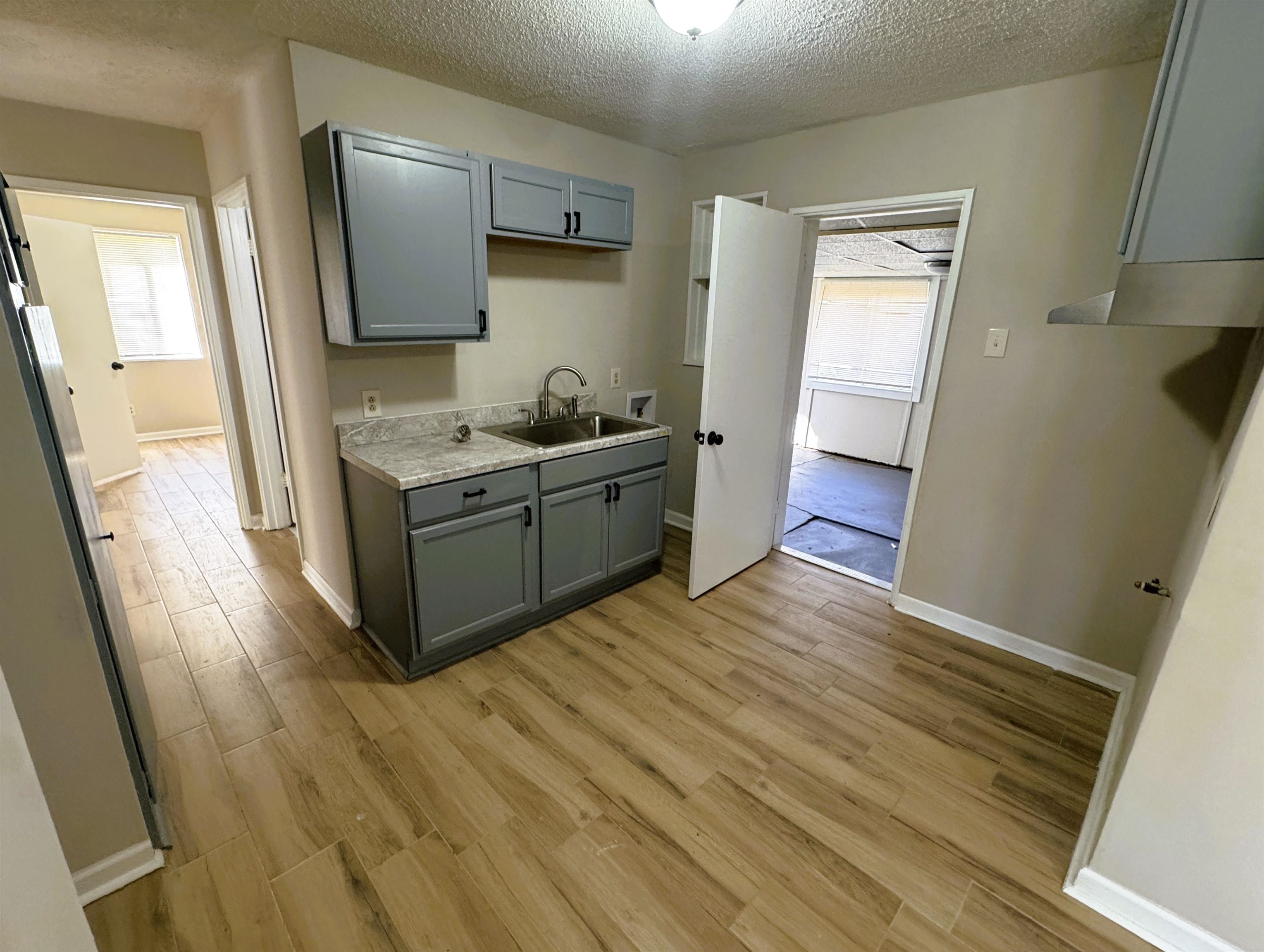961 North Perkins Road Memphis, TN 38122 - Photo 5 of 15 Kitchen featuring gray cabinetry, a textured ceiling, light wood finished floors, and light countertops