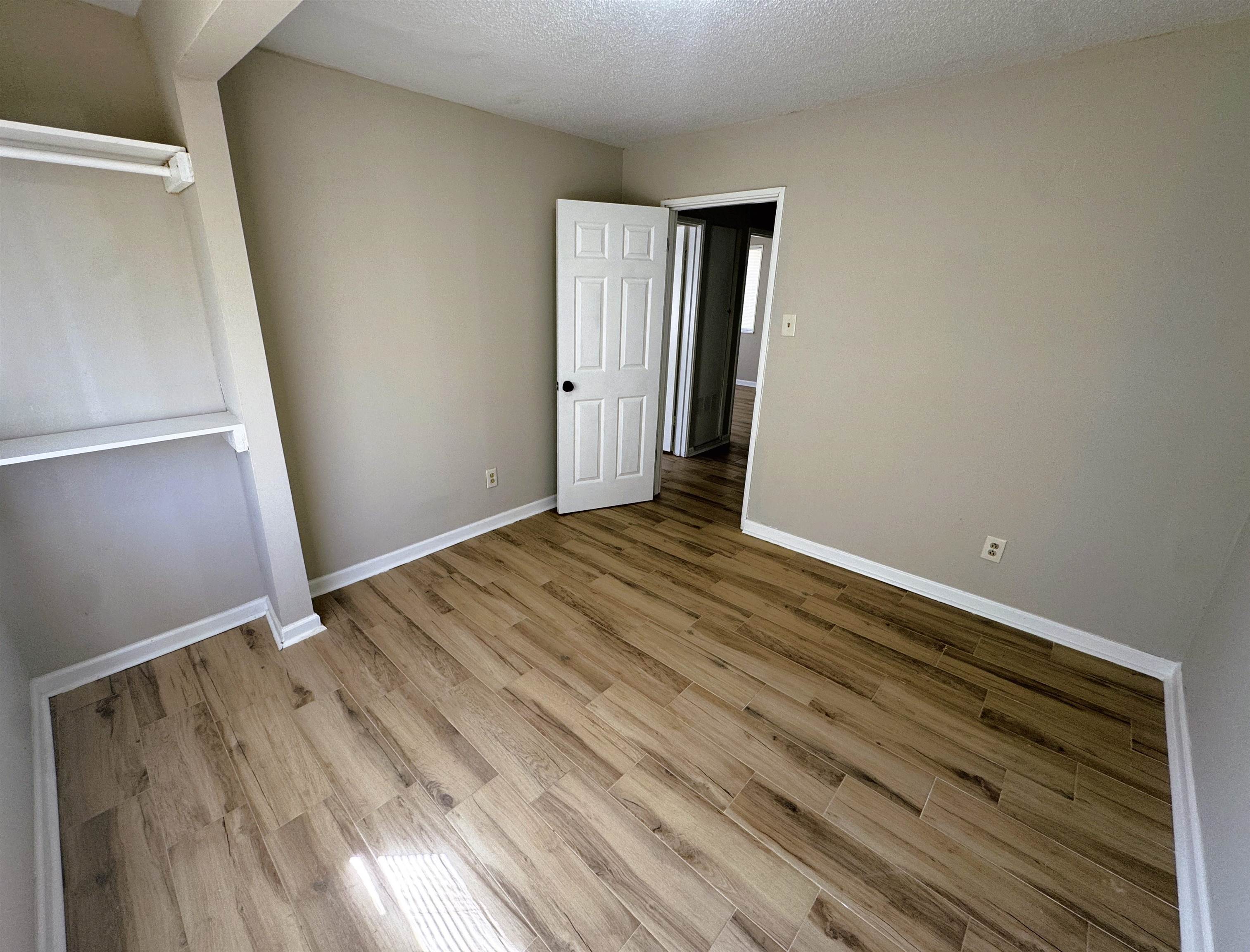 961 North Perkins Road Memphis, TN 38122 - Photo 7 of 15 Unfurnished bedroom with light wood finished floors and a textured ceiling