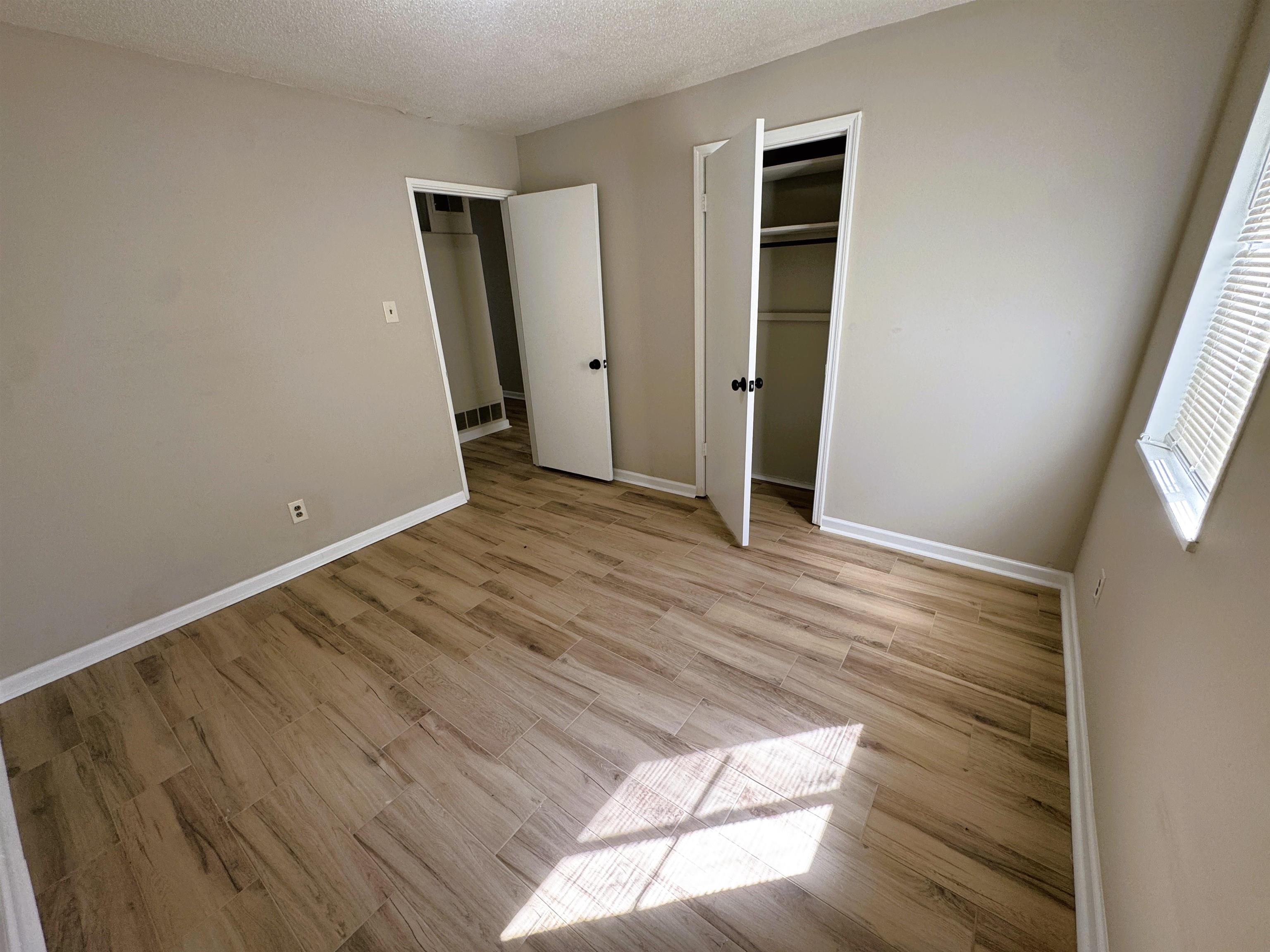 961 North Perkins Road Memphis, TN 38122 - Photo 9 of 15 Unfurnished bedroom featuring light wood-type flooring, a textured ceiling, and a closet