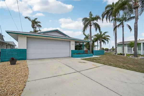 a view of a house with a yard and palm trees