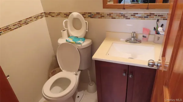 a bathroom with a toilet mirror and vanity