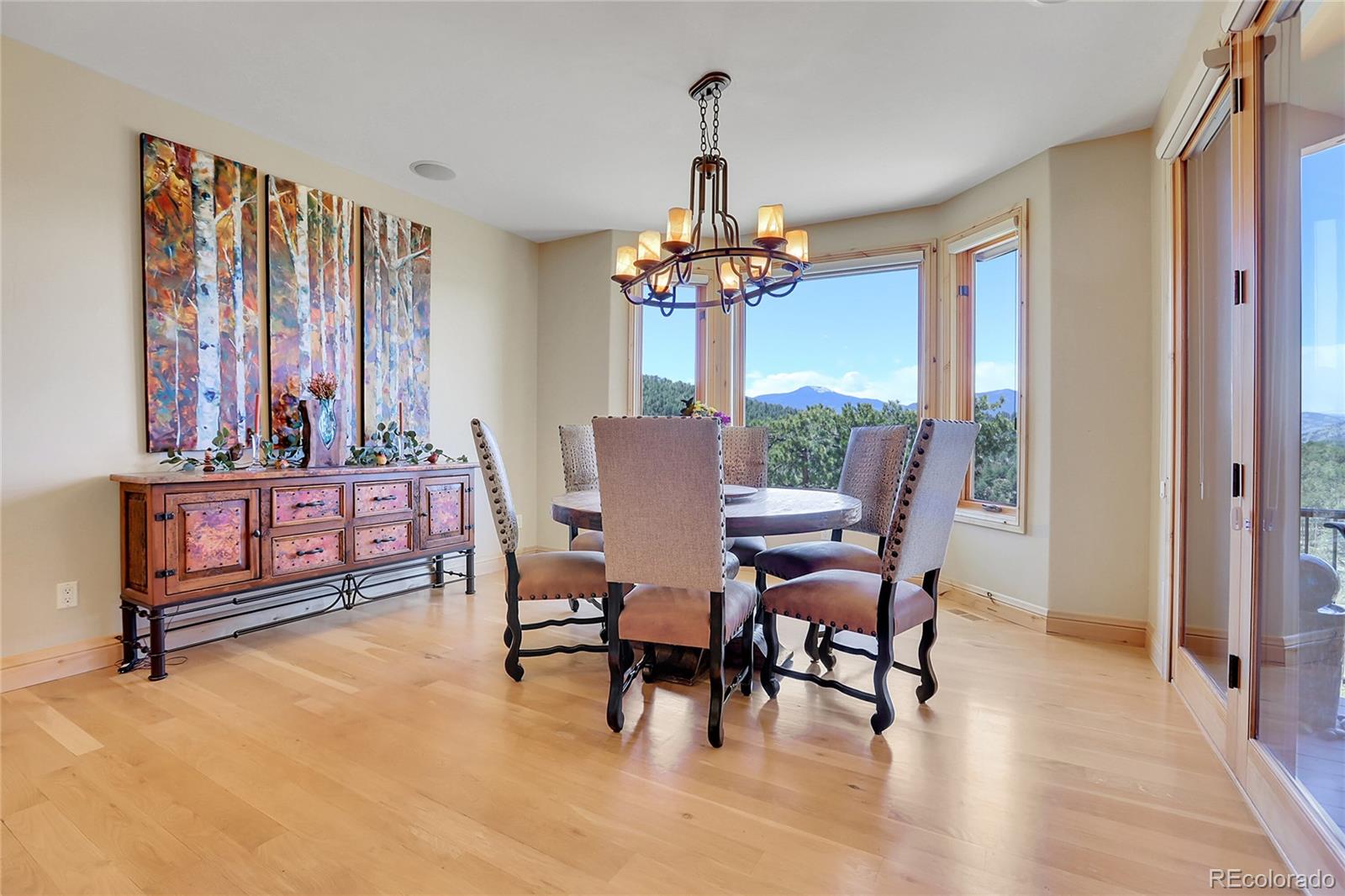 1007 Nob Hill Road Evergreen, CO 80439 - Photo 17 of 48 a dining room with furniture a chandelier and wooden floor