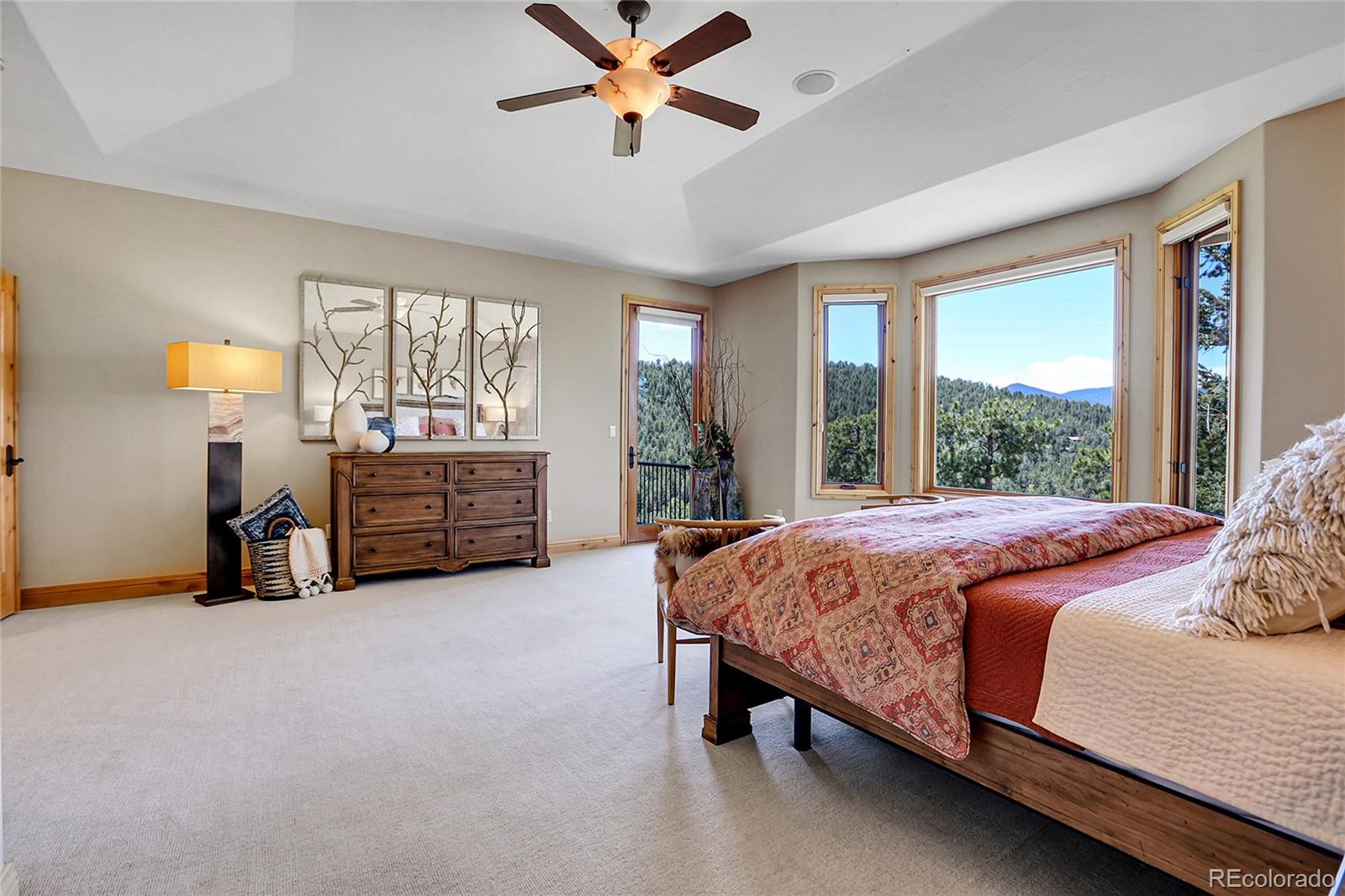 1007 Nob Hill Road Evergreen, CO 80439 - Photo 21 of 48 a bed sitting in a spacious bedroom next to a window
