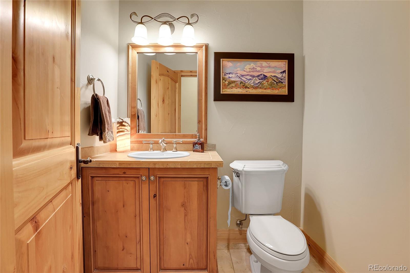 1007 Nob Hill Road Evergreen, CO 80439 - Photo 27 of 48 a bathroom with a toilet a sink and mirror