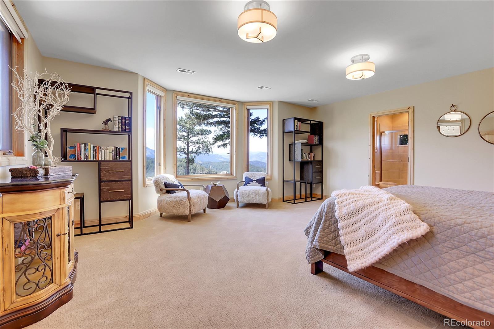 1007 Nob Hill Road Evergreen, CO 80439 - Photo 38 of 48 a spacious bedroom with a bed and a large window