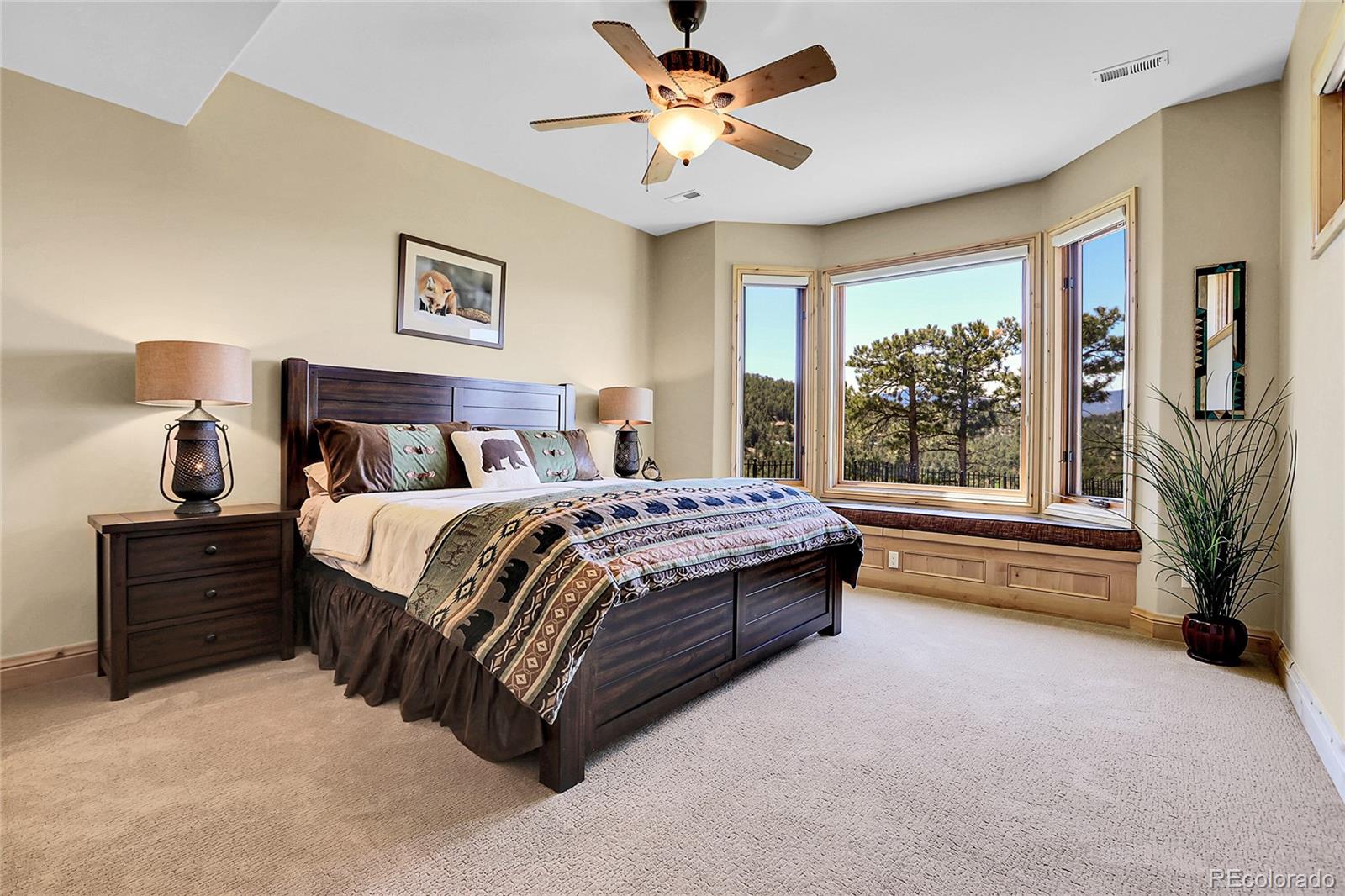 1007 Nob Hill Road Evergreen, CO 80439 - Photo 40 of 48 a spacious bedroom with a bed and a chandelier