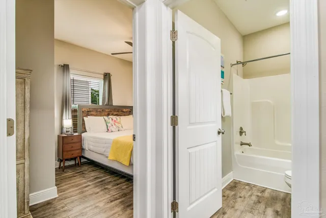 a bathroom with a tub shower and hardwood floor