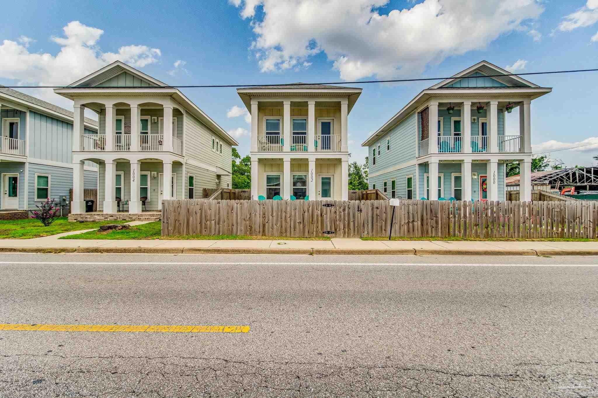 1002 West Main Street Pensacola, FL 32502 - Photo 25 of 32 a view of a house with a swimming pool and a yard